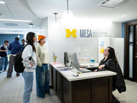 Students and staff having a conversation at MESA's front desk in the Michigan Union